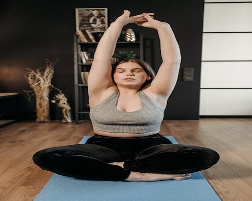 A person stretching their arms while sitting at a home desk