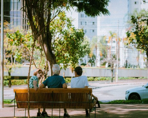 People sitting on a bench in a bright urban environment